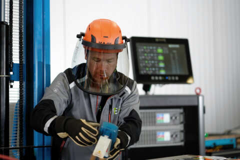 Arbeiter misst Entladung an einer Batterie